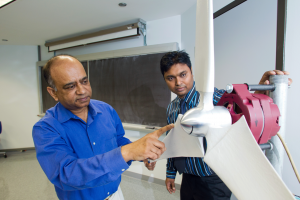 UM-Flint Mechanical Engineering Professor Quamrul Mazumder and student Saiful Siddique examine a wind turbine