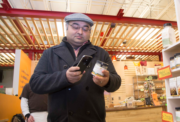 UM-Flint associate professor of marketing Sy Banerjee uses his smart phone while shopping.