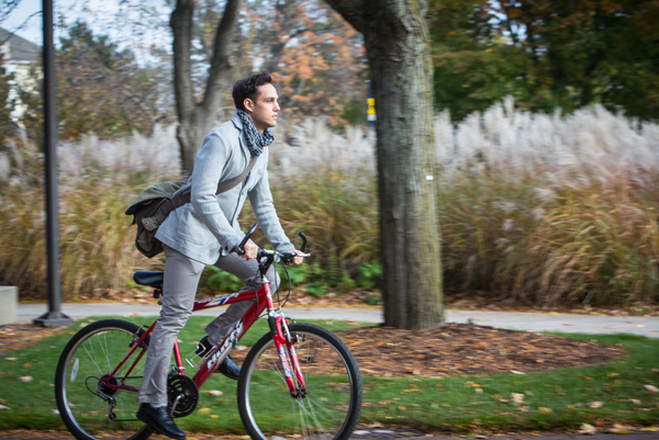 UM-Flint student rides bike down Kearsley Street.