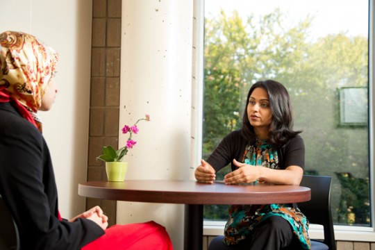 Women's Education Center director Rushika Patel, PhD talks with a UM-Flint student.