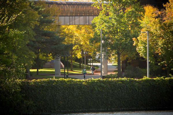 UM-Flint students walking on campus near the Flint River.