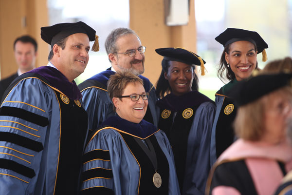 Regents Michael Behm, Katherine White, and Shauna Ryder Diggs with U-M President Mark Schlissel and UM-Flint Chancellor Susan E. Borrego.