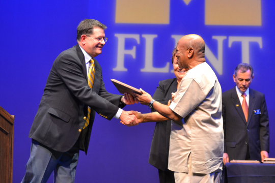 Provost Douglas Knerr presents award to Africana Studies professor Ernest Emenyonu