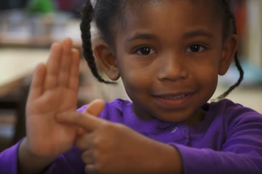 UM-Flint Early Childhood Development Center youngster shows where Flint is on her palm.
