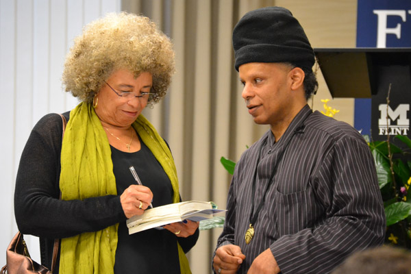 Angela Davis signs a book for a faculty forum participant at UM-Flint.