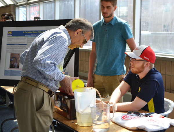 Professor Mojtaba Vaziri of UM-Flint Engineering examines the portable water filtration system.