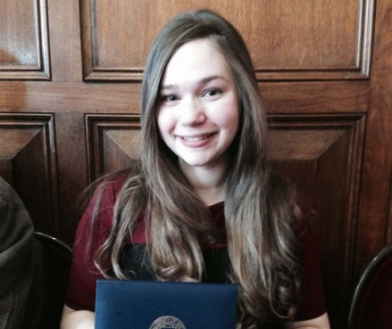 Elena Sobrino holds her Angell Scholar award for eight straight semesters of earning A's at UM-Flint. 