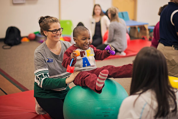 UM-Flint PT students working with child from University's Early Childhood Development Center
