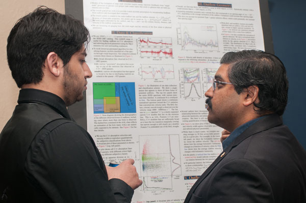 UM-Flint associate professor of physics Rajib Ganguly, Ph.D. (right) discusses poster presentation.