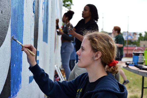 UM-Flint Visual Art students paint murals along Saginaw Street in Flint.