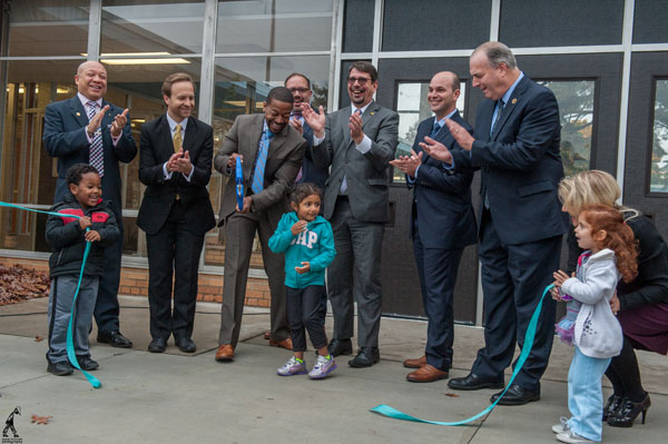 Educators and legislators cut ribbon to open new early childhood center.