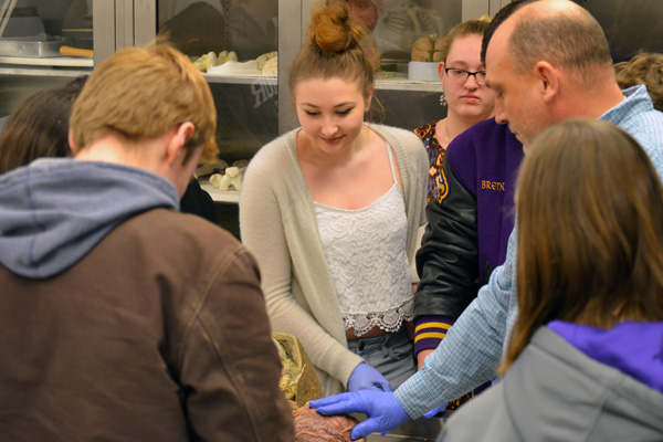 Dennis Viele of UM-Flint biology leads students in interacting with a cadaver.