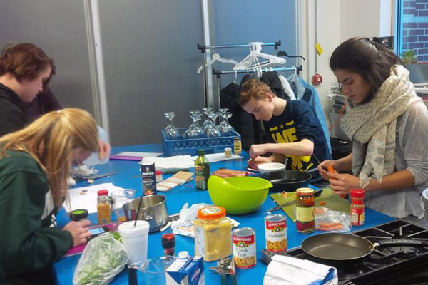 Students cooking at the Flint Farmers' Market kitchen for their UNV 100 final exam