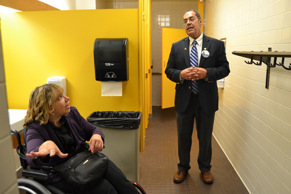 Lizotte (left) explains issues that can arise for wheelchair users in public bathrooms to State Representative Tim Sneller during his Take Your Legislator to Work Day visit.