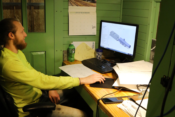 Uriah Horton creating CAD drawings in his caboose office inside the Huckleberry Railroad Locomotive Repair Shop. 