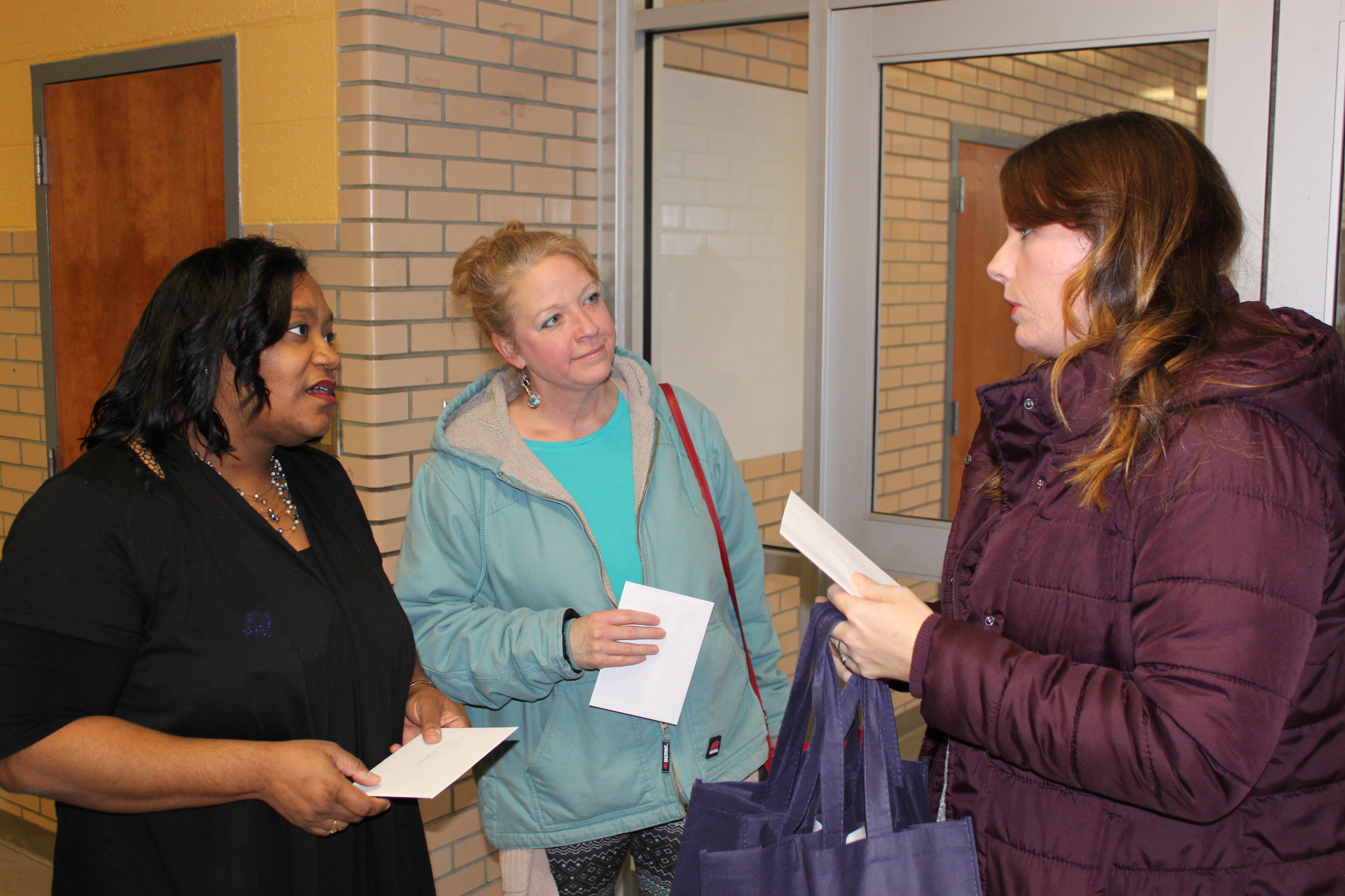 Shearese Stapleton and Vicki Cantrell are greeted by UM-Flint Staff Council member Melissa Richardson.