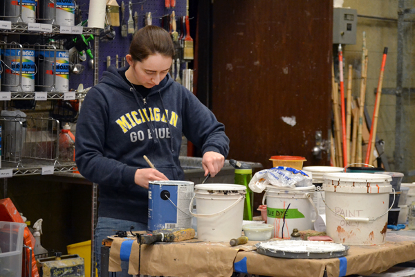 UM-Flint Theatre student Sarah Briggs mixing paint in the Scene Shop