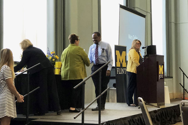 Chancellor Susan E. Borrego congratulates associate professor of sociology Charles Thomas Jr., PhD, on his 30 years of service to UM-Flint students.