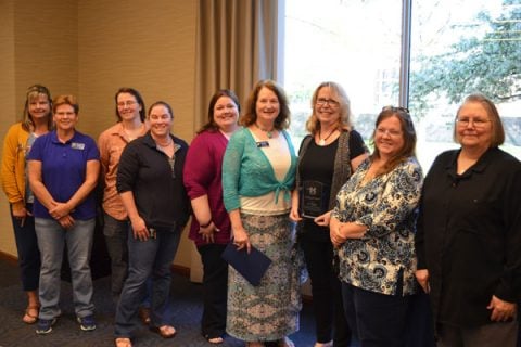 Jo Klingler (holding award) of UM-Flint's Department of Public Health and Health Sciences received the 2018 Staff Recognition Award.