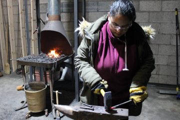 UM-Flint student Andleeb Baig makes a rivet the old fashion way at the Forge at Factory Two.