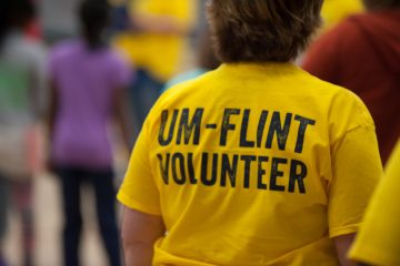 A member of the campus community volunteering at a UM-Flint event.