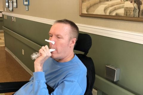 A resident of The Boston Home does respiratory exercises