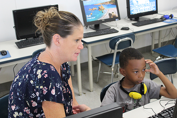 Kristie Yammine, Literacy Education (MA) graduate and literacy coach at McMonagle Elementary in Flint, works with a student. 