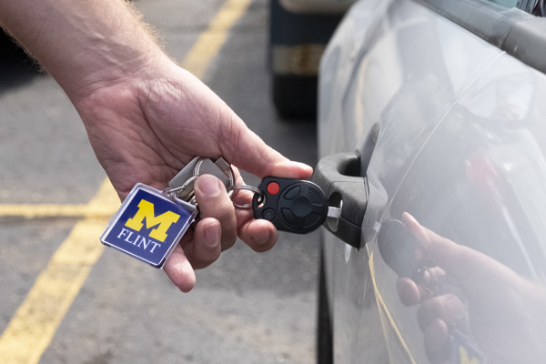 Someone unlocking their car door with a key.