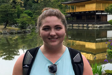 Haylee Skank next to a Japanese historical building