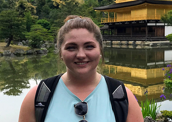 Haylee Skank next to a Japanese historical building