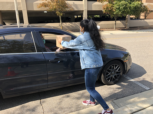 Students distribute supplies in a campus drive through