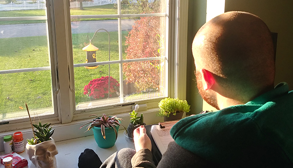 Tyler Lancaster looking out his window to study birds