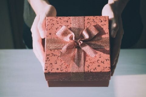 A person holding a wrapped present