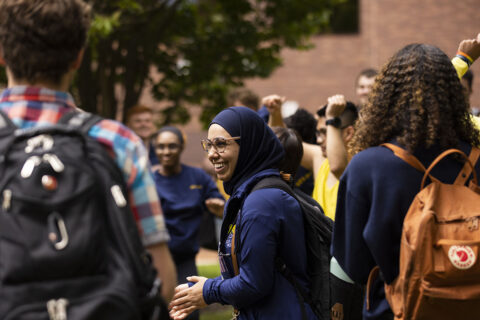 a woman laughing in an outside crowd