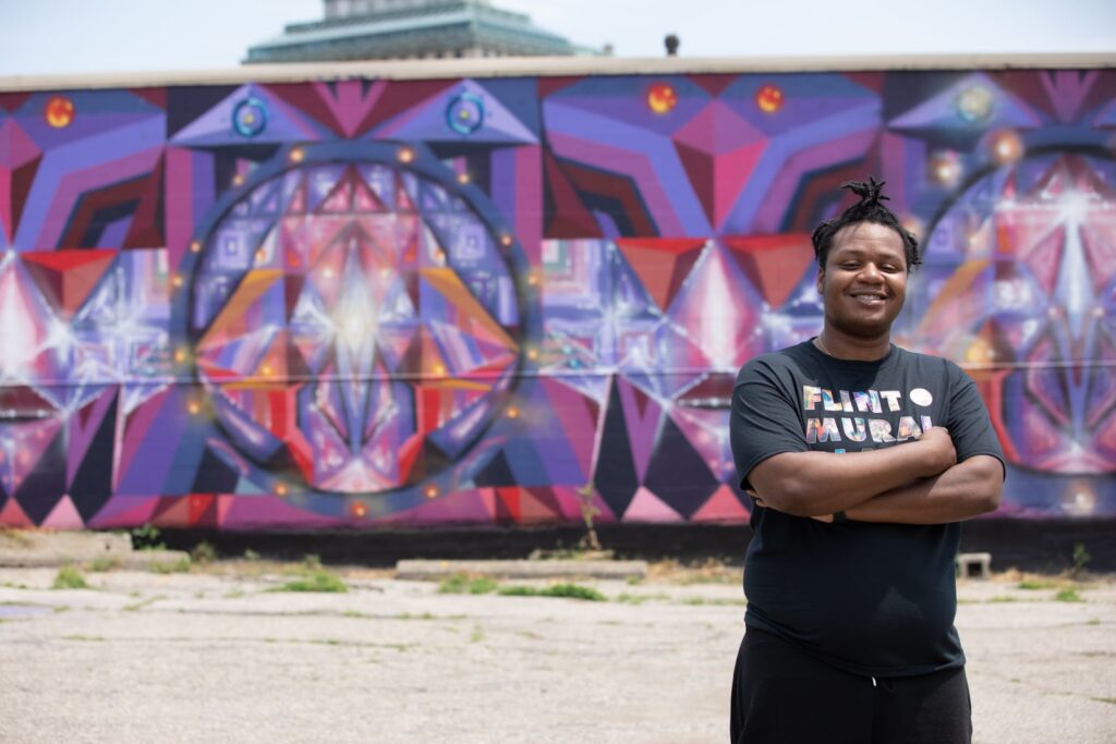 David Guster in front of a mural