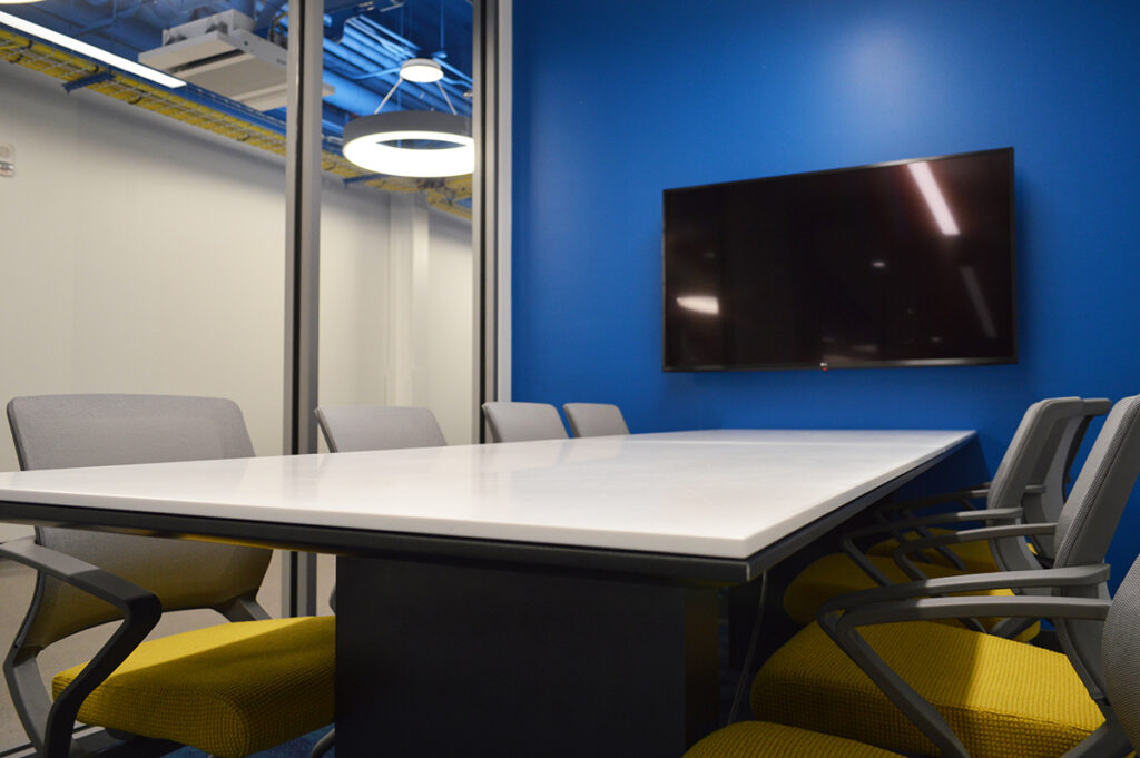 A table with a TV screen on the wall. 