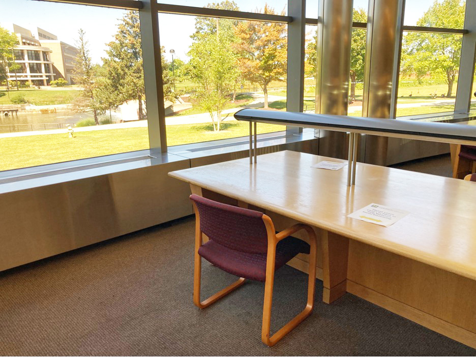 desks next to large windows in the library atrium