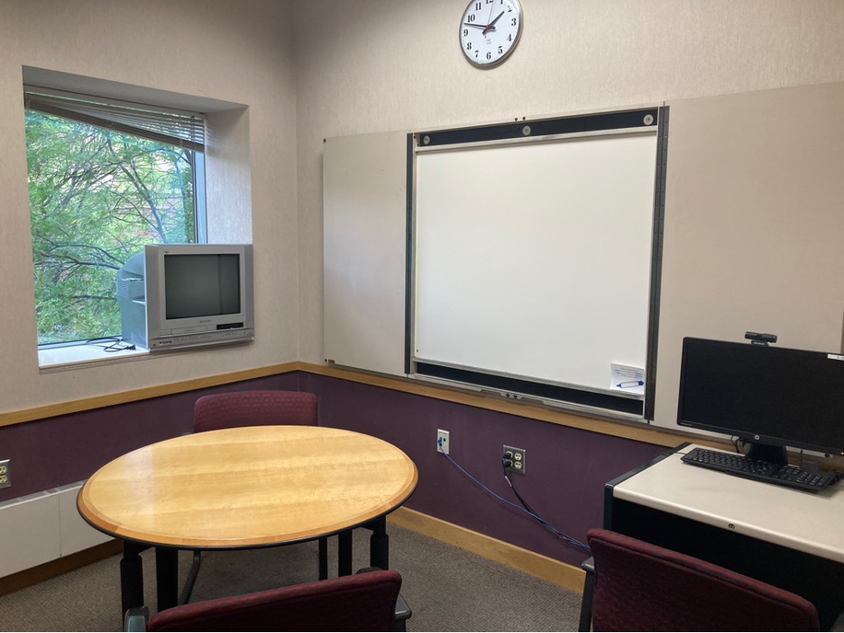 A study room with a whiteboard and tables. 