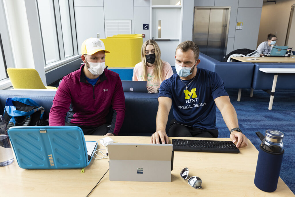 Three students working on laptops