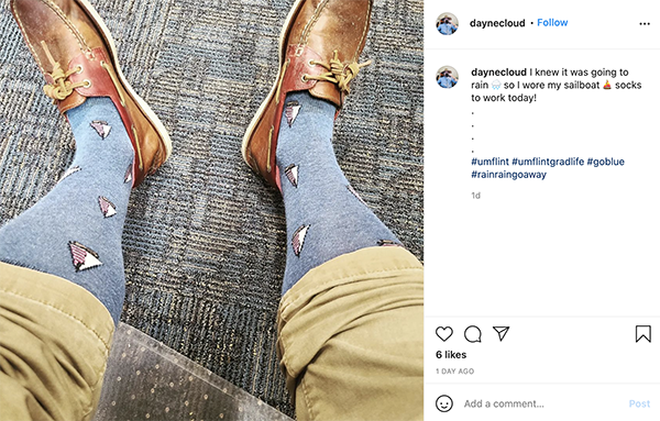 rolled up pants displaying dress socks with sailboats on them. 