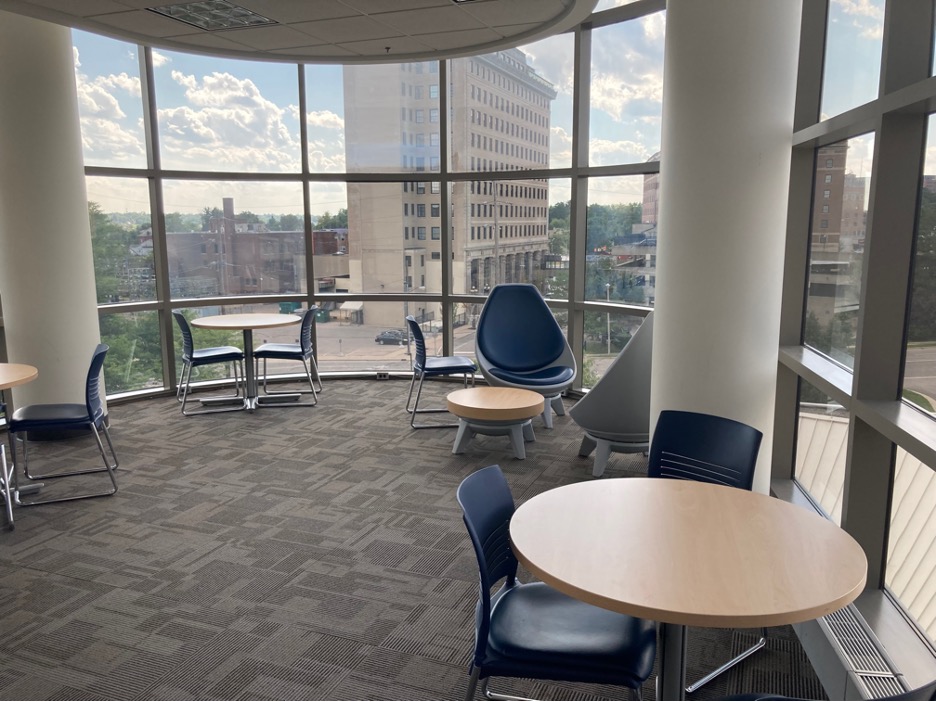 Chairs and tables next to windows showing a view of Flint