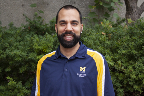 A man, David Luke, smiling for the camera wearing a UM-Flint polo