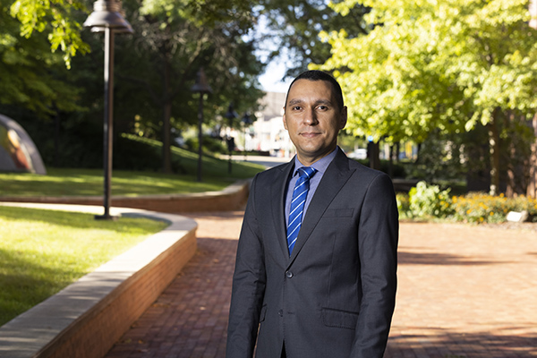 Thiago Ferreira standing outside on campus wearing a suit.