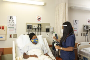 Two UM-Flint nursing students train with one acting as a patient.