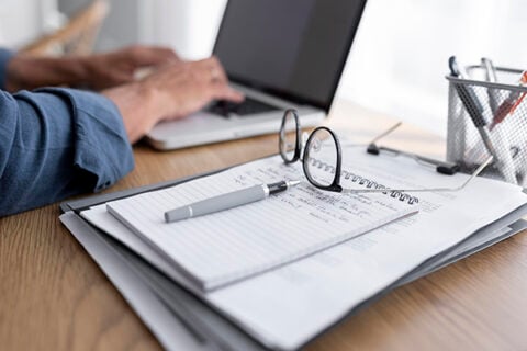 hands using a laptop on a desk