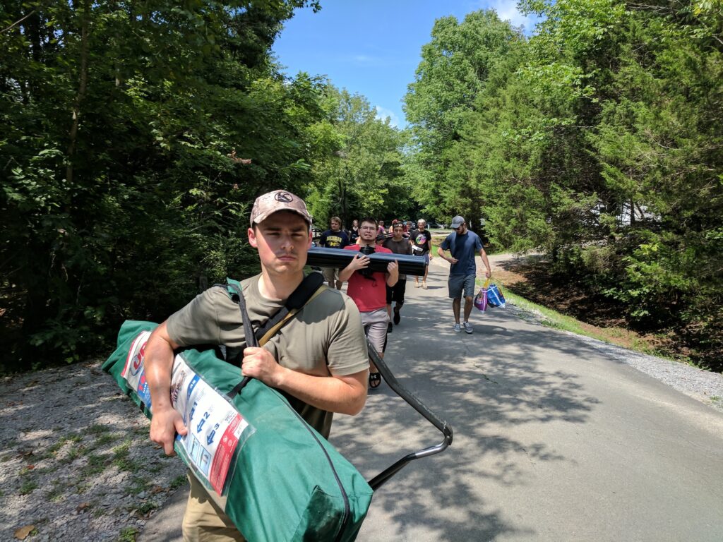 Society of Physics Students walk with camping gear on a trail 