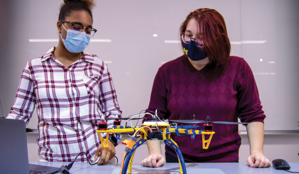 Two Students from the College of Health Sciences with a drone that they built