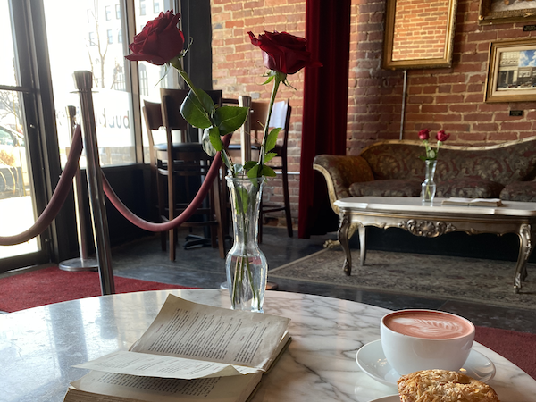 Open book, coffee, muffin, and flower centerpiece at Cafe Rhema table 