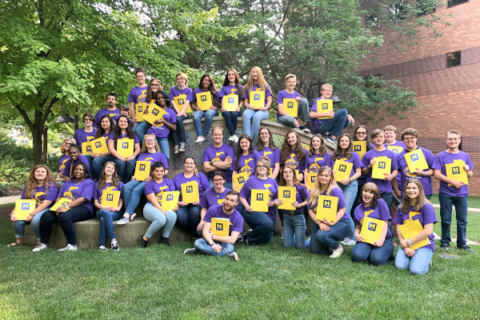 A group of UM-Flint and K12 students wearing Summer Vocal Academy of Music shirts.