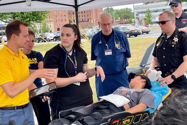 Faculty and first responders work with a volunteer patient during an accident simulation.